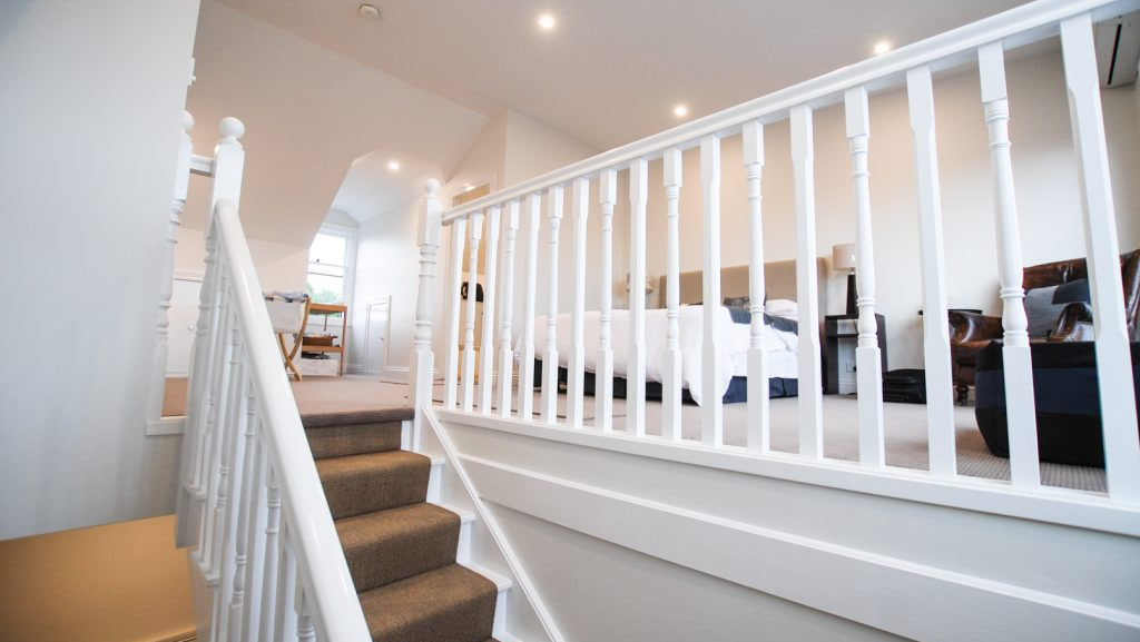 Attic staircase with white banister and railing - view up to habitable attic room